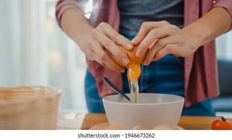 Hands of young Asian woman chef cracking eggs into ceramic bowl cooking omelette with vegetables on wooden board on kitchen table in house. Lifestyle healthy eating and traditional bakery concept. - Powered by Shutterstock