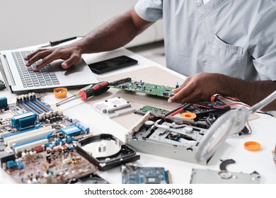 Hands of young blackman typing while holding part of hardware during repairing work
