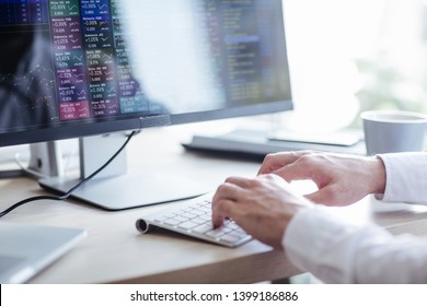 Hands eines jungen Geschäftsmanns, der auf einer Tastatur tippt, während er an einem Desktop-Computer im modernen Bürobereich arbeitet.