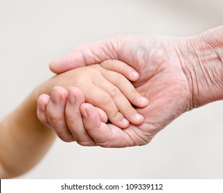 Hands Of Young Child And Old Senior