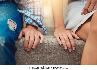 Hands of young couple in love close side by side on the first date. Loving couple has a happy relationships. First love concept.