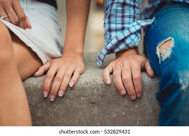 Hands of young couple in love close side by side on the first date