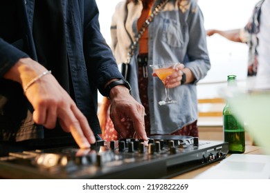 Hands Of Young Male Deejay Rotating Turntables While Creating Dance Music For People Enjoying Rooftop Party On Terrace Of Outdoor Cafe