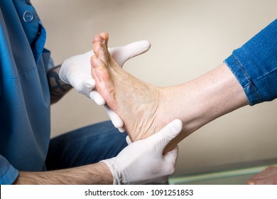 The hands of a young man doctor orthopedist conducts diagnostics, foot foot test of a woman, for the manufacture of individual, orthopedic insoles.