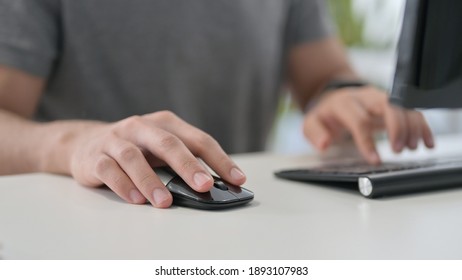 Hands of Young Man Using Mouse on Desktop, Close Up 