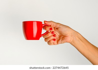 hands of a young woman holding a red cup of coffee, white background. - Powered by Shutterstock