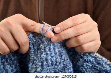 Hands of a young woman knitting with blue wool - Shutterstock ID 127050815
