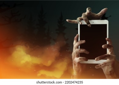 Hands of zombies with tablet computer on dark background - Powered by Shutterstock