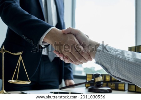 Handshake after Lawyer  providing legal consult business dispute service to the man at the office with justice scale and gavel hammer.