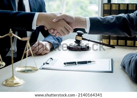 Handshake after Lawyer  providing legal consult business dispute service to the man at the office with justice scale and gavel hammer.