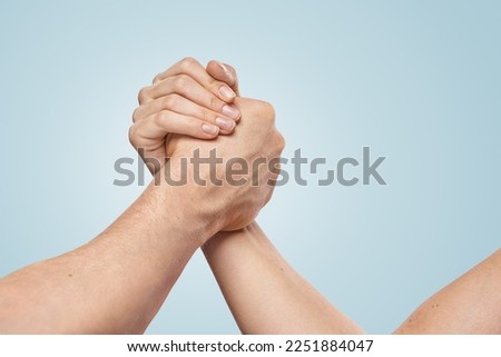 Handshake arm wrestling style by a woman and a man. Friendly, sport handshake gesture concept. Equal rights, Kindness Concept