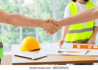 Handshake between construction workers over project plans