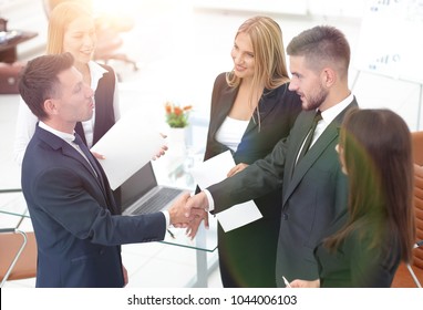 Händeschütteln der Geschäftspartner nach Vertragsunterzeichnung