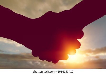Handshake. Business people shake hands in nature background in the sun.