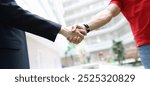 Handshake businessman and men in a red T-shirt, close-up. Freelancer, cooperation agreement. Promotion