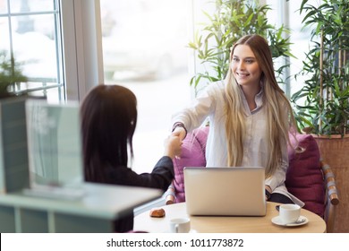 Handshake Of Businesswomen Owner Of Small Business During Lunch Break In Cafe. Interview Of Young Hipster Aspirant Concept