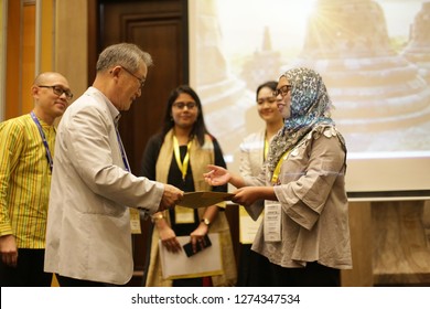 handshake certificate give to woman on stage. hand with certificate. yogyakarta indonesia. january 04, 2019.