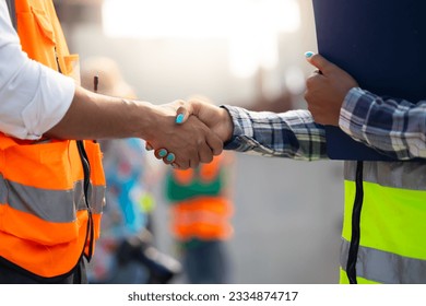 Handshake. Close up construction worker people shaking hands on business cooperation agreement. Successful hands shaking after good deal - Powered by Shutterstock