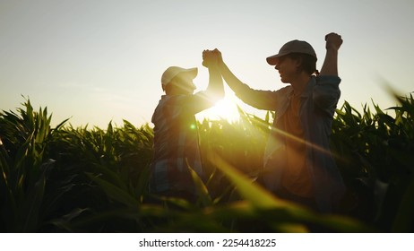 handshake farmer corn. business a partnership agriculture concept. silhouette two farmers shaking hands conclude contract agreement in field of corn glare sun. agriculture business handshake concept
