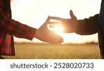 handshake farmers business contract. agriculture business farm concept. handshake business contract of two farmers close-up. handshake workers in lifestyle a field with wheat at sunset