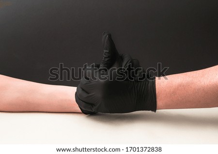 Handshake with gloves during a pandemic quarantine. hands isolated on blue background 