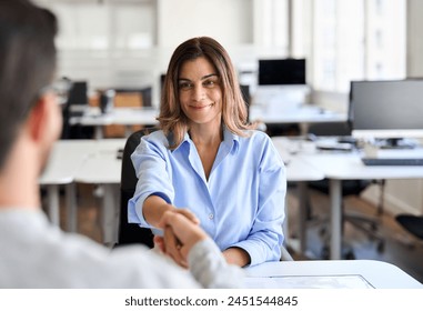 Handshake of happy middle aged female hr, bank manager, financial advisor and male recruit, partner or client during business meeting. Hiring at job interview, partnership, corporate agreement. - Powered by Shutterstock