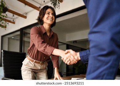 Handshake of happy young business woman and business man at office meeting. Female hr bank manager, financial advisor handshaking recruit, greeting client. Hiring at job interview, partnership concept - Powered by Shutterstock