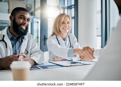 Handshake, partnership or happy doctors in a meeting after successful medical surgery or reaching healthcare goals. Teamwork, woman or black man smiles shaking hands with a worker in hospital office - Powered by Shutterstock