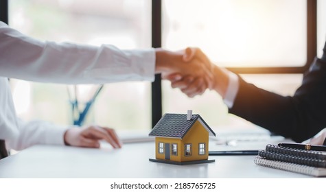 Handshake real estate agents deliver sample homes to customers. mortgage loan agreement Make a contract for hire purchase and sale of a house. and home insurance contracts home mortgage loan concept - Shutterstock ID 2185765725