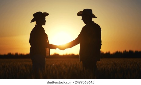 handshake silhouette farmers business contract. agriculture business farm concept. handshake business contract of two farmers. handshake workers in field with wheat at sunset lifestyle - Powered by Shutterstock