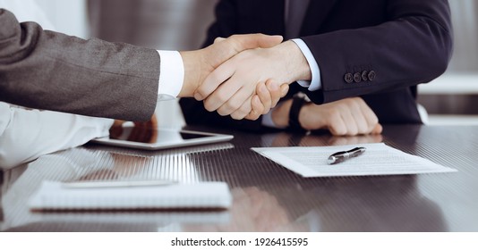 Handshake As Successful Negotiation Ending, Close-up. Unknown Business People Shaking Hands After Contract Signing In Modern Office