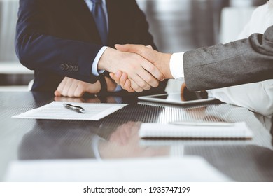 Handshake As Successful Negotiation Ending, Close-up. Unknown Business People Shaking Hands After Contract Signing In Modern Office