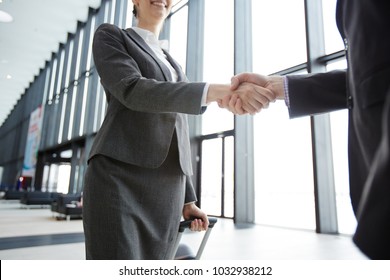 Handshake of traveling business partners in lounge of modern airport - Powered by Shutterstock