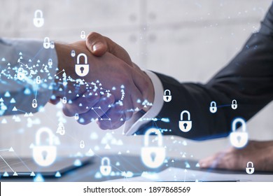 Handshake of two businessmen who enters into the contract to protect cyber security of international company. Padlock Hologram icons over the table with documents. - Shutterstock ID 1897868569