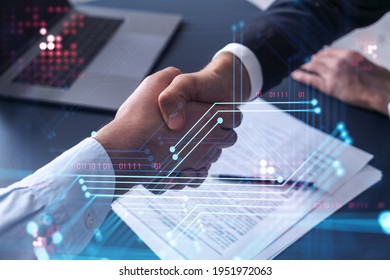 Handshake of two businessmen who enters into the contract to develop a new software to improve business service at a company. Technological icons over the table with the document.
