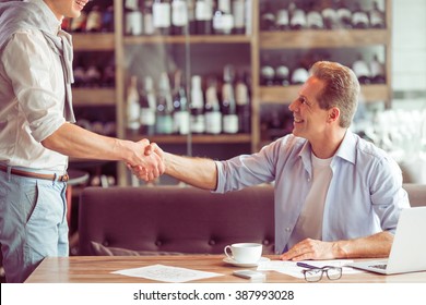 Handshake of two handsome businessmen in casual clothes meeting for working at the restaurant - Powered by Shutterstock