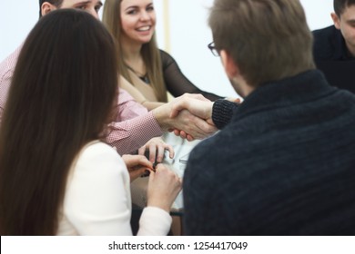 handshake of two men at a table in a creative office