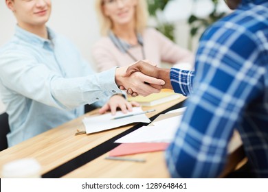 Handshake Of Two Young Intercultural Business Partners Or Colleagues After Discussing Working Points And Coming To Terms