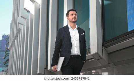 Handsome 30s top manager walking in formal suit. Successful entrepreneur stroll urban city street. Confident serious business man. Young male businessman. 40s employee job. Office work. CEO boss gait. - Powered by Shutterstock