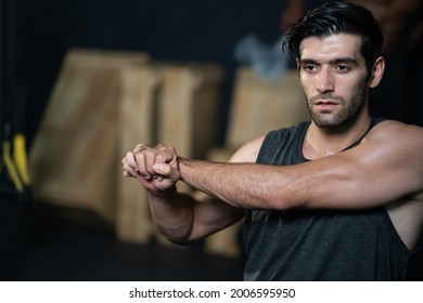 Handsome adult Caucasian men warm up and stretching before do crossfit exercise inside of fitness gym to workout for body strength and firm arms muscle and good physical body health.