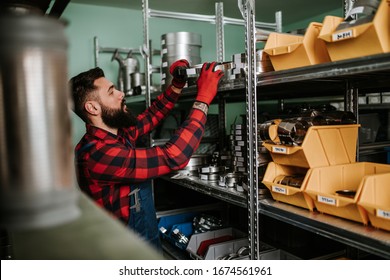 Handsome Adult Man Working In Car And Truck Spare Parts Warehouse. 