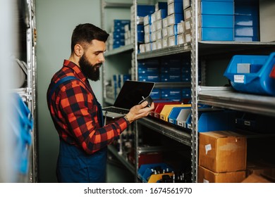 Handsome Adult Man Working In Car And Truck Spare Parts Warehouse. 