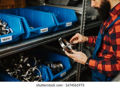 Handsome Adult Man Working In Car And Truck Spare Parts Warehouse. 