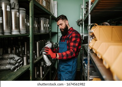 Handsome Adult Man Working In Car And Truck Spare Parts Warehouse. 