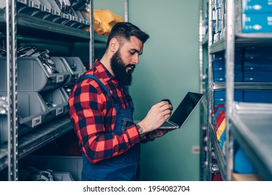 Handsome Adult Man Working In Car And Truck Spare Parts Warehouse. 