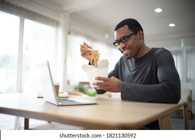 Handsome African American Freelancer Eating Takeaway Asian Food, Spaghetti With Chopsticks.He Online Together With His Friends On Video Call Virtual Party In Quarantine Time. Coronavirus Outbreak.