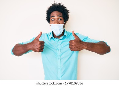 Handsome African American Man With Afro Hair Wearing Medical Mask Smiling And Laughing Hard Out Loud Because Funny Crazy Joke. 