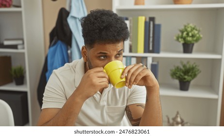 Handsome african american man drinking coffee at home, in a modern living room setting. - Powered by Shutterstock