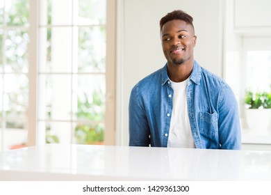 Handsome african american man at home looking away to side with smile on face, natural expression. Laughing confident. - Shutterstock ID 1429361300
