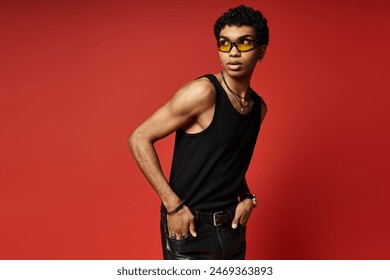 Handsome African American man posing in stylish sunglasses, black tank top, and leather pants. - Powered by Shutterstock